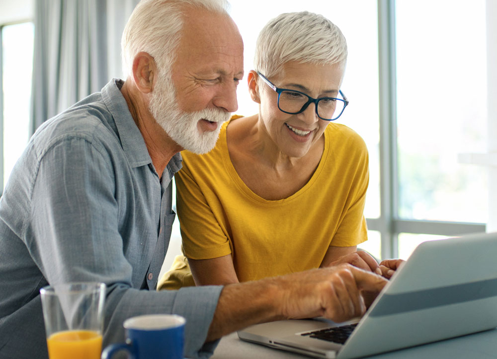 Elderly couple looking at a laptop together